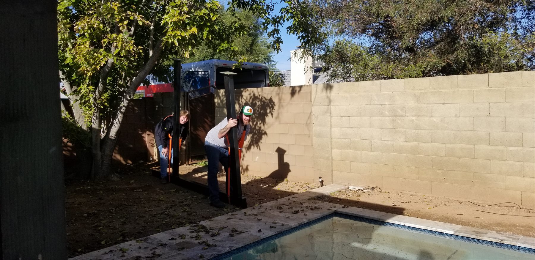 Pergola frame pieces carried into backyard